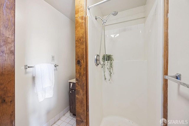 full bathroom with a stall shower, vanity, and tile patterned flooring