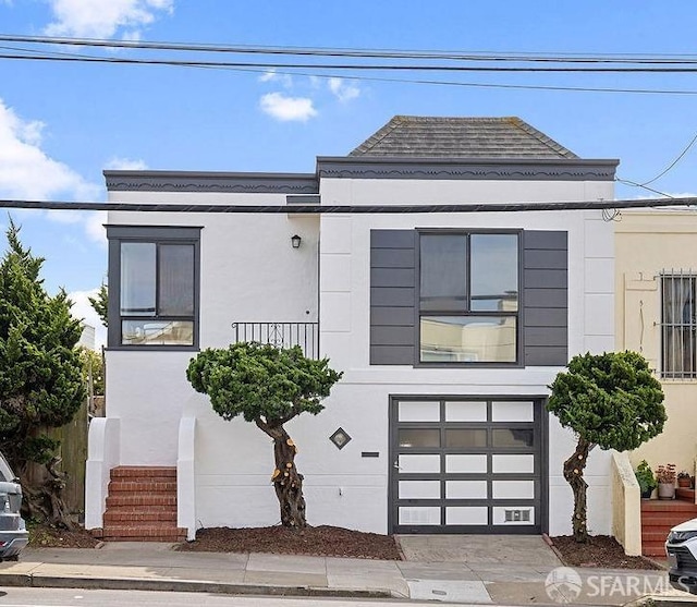 view of front facade featuring stucco siding, driveway, and an attached garage