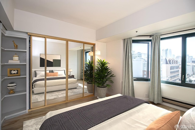 601 Van Ness Ave Unit 712, San Francisco, CA 94102 - bedroom featuring wood finished floors, a baseboard heating unit, and a closet