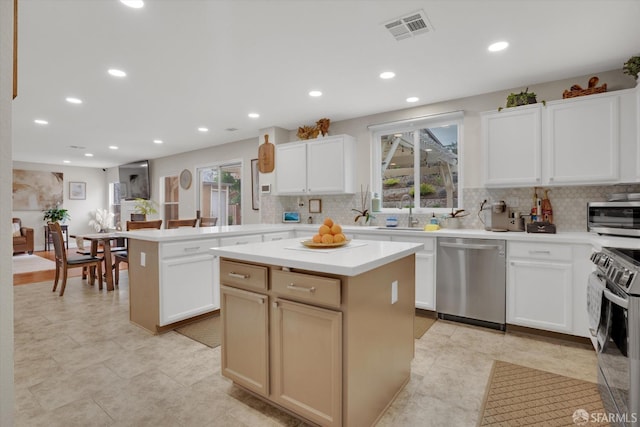 kitchen featuring visible vents, appliances with stainless steel finishes, a wealth of natural light, and a center island