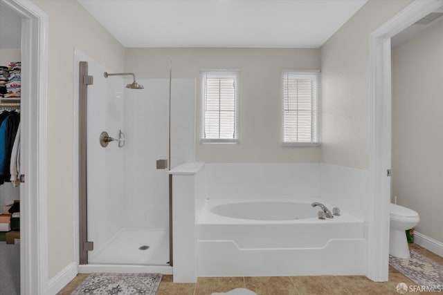 full bath featuring toilet, a stall shower, tile patterned flooring, and a bath