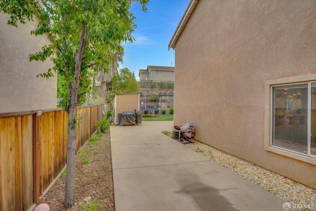 view of patio featuring a trampoline and fence