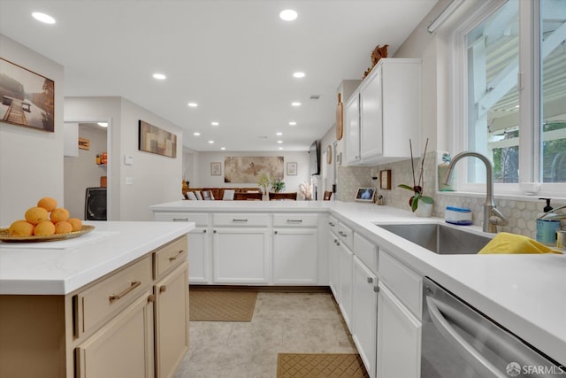 kitchen with recessed lighting, a peninsula, a sink, decorative backsplash, and dishwasher