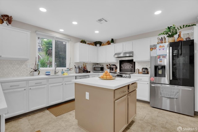 kitchen featuring white cabinets, appliances with stainless steel finishes, light countertops, under cabinet range hood, and backsplash