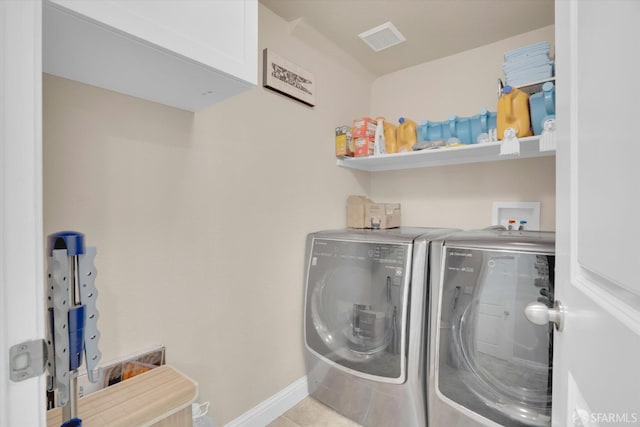 laundry area with laundry area, visible vents, washer and clothes dryer, baseboards, and tile patterned flooring