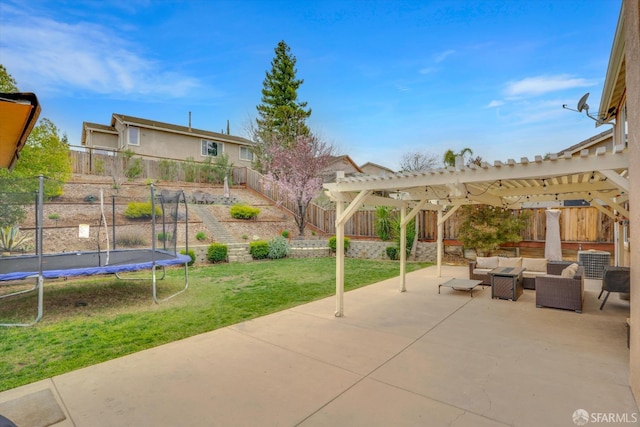 view of patio featuring a trampoline, a fenced backyard, an outdoor living space, and a pergola