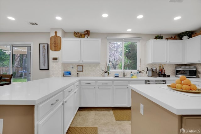 kitchen featuring light countertops, visible vents, a peninsula, and light tile patterned floors