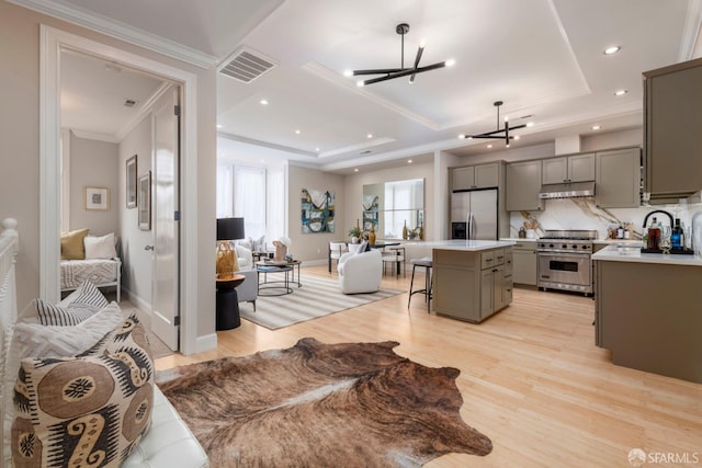 2675 Sutter St, San Francisco, CA 94115 - living area with a chandelier, light wood-style flooring, a tray ceiling, crown molding, and recessed lighting