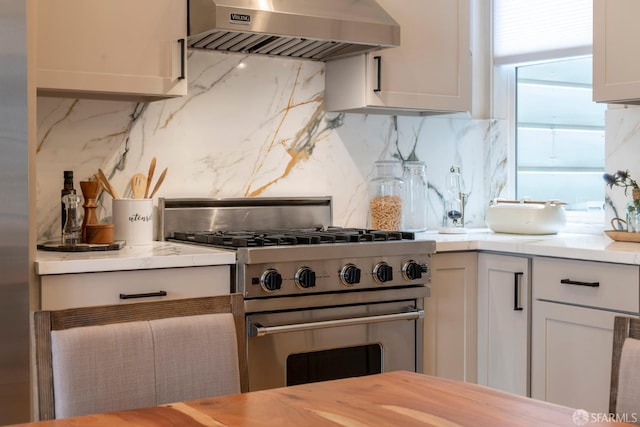 2675 Sutter St, San Francisco, CA 94115 - kitchen with wall chimney range hood, stainless steel range, decorative backsplash, and light countertops
