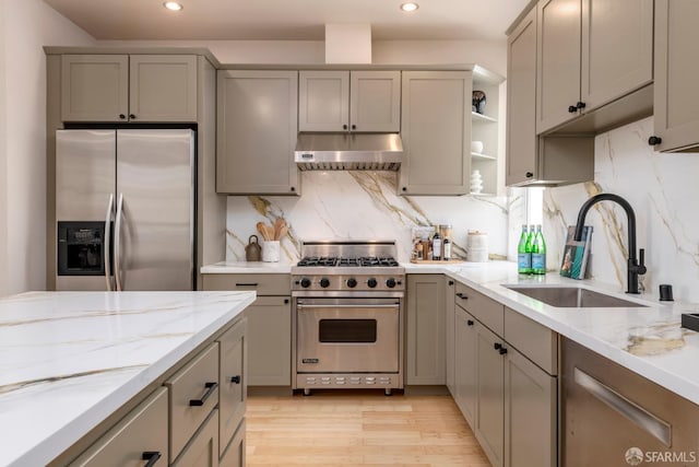 2675 Sutter St, San Francisco, CA 94115 - kitchen with stainless steel appliances, under cabinet range hood, gray cabinets, recessed lighting, and light stone counters