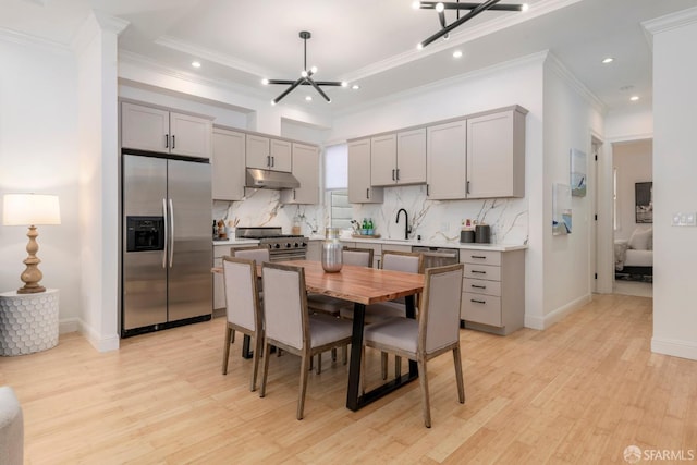 2675 Sutter St, San Francisco, CA 94115 - kitchen with stainless steel appliances, gray cabinetry, under cabinet range hood, light wood-style flooring, and recessed lighting