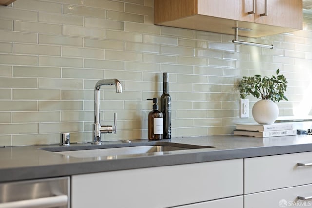 kitchen with sink, backsplash, and stainless steel dishwasher