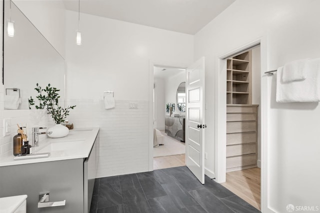 bathroom with vanity and tile walls