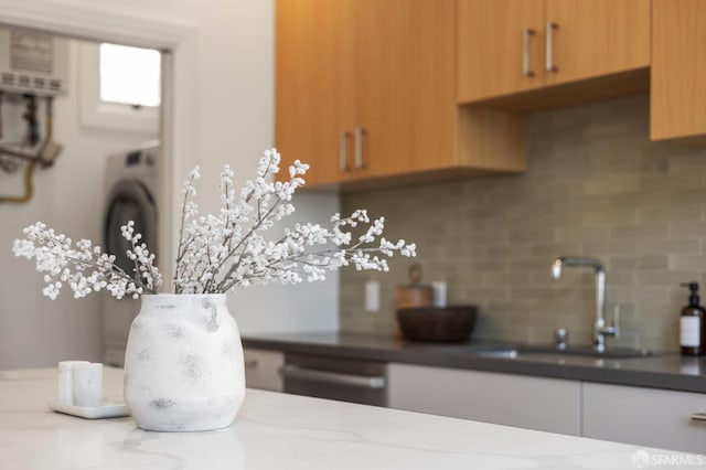 interior space with tasteful backsplash, dishwasher, and sink