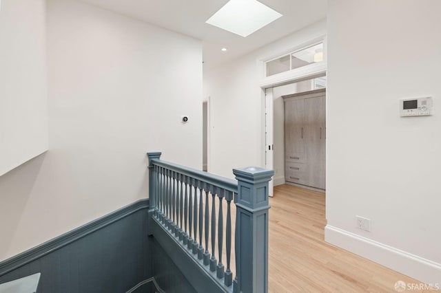 hall featuring a skylight and light hardwood / wood-style floors