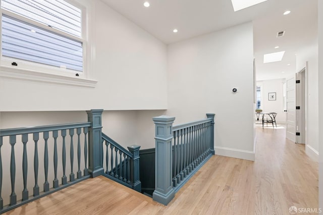 interior space with a skylight, light hardwood / wood-style floors, and plenty of natural light