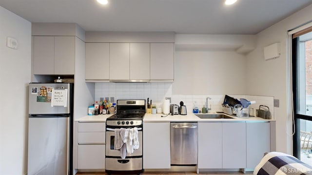 kitchen featuring tasteful backsplash, sink, range hood, white cabinets, and stainless steel appliances