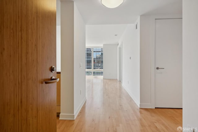 301 Mission St Unit 16H, San Francisco, CA 94105 - hallway featuring light wood-style flooring and a wall of windows