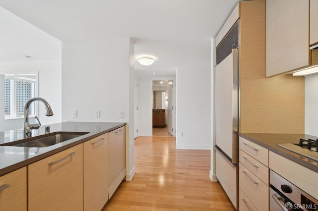 301 Mission St Unit 16H, San Francisco, CA 94105 - kitchen featuring light wood-style flooring, stainless steel oven, dark countertops, light brown cabinets, and gas stovetop