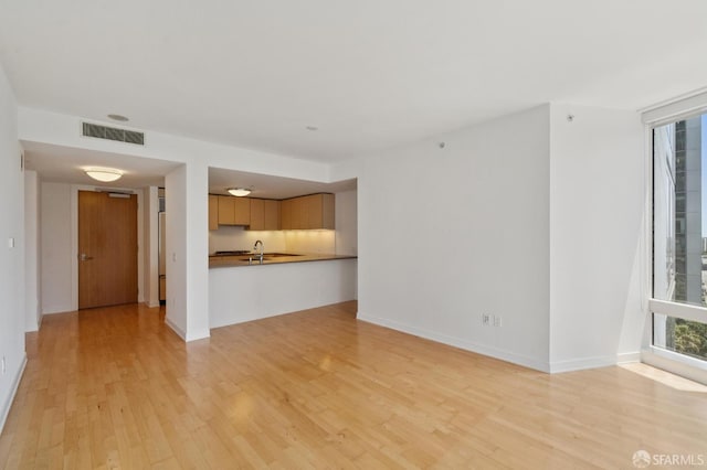 301 Mission St Unit 16H, San Francisco, CA 94105 - unfurnished living room featuring light wood-style flooring and a sink