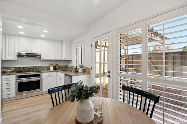 dining room with sink and light wood-type flooring