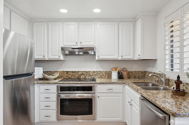 kitchen with appliances with stainless steel finishes, sink, and white cabinets