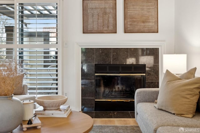 living area with a tiled fireplace and hardwood / wood-style floors