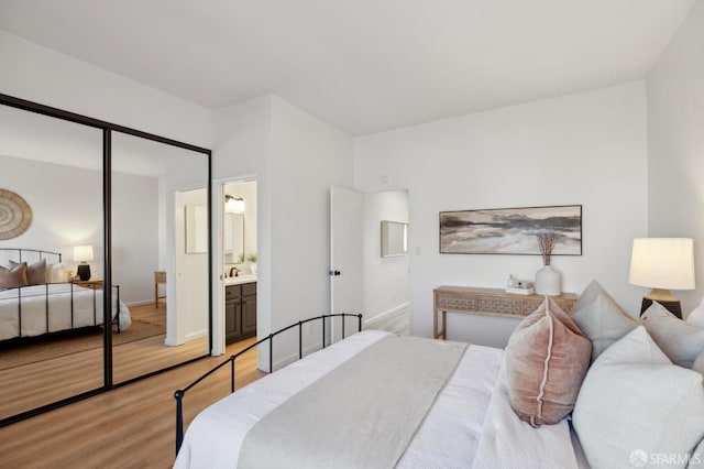 bedroom with hardwood / wood-style flooring and ensuite bathroom