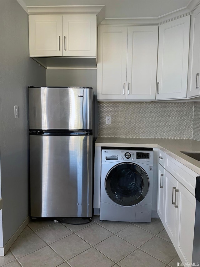 washroom featuring washer / clothes dryer and light tile patterned flooring