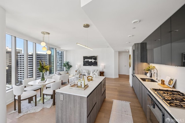 338 Main St Unit 19G, San Francisco, CA 94105 - kitchen with modern cabinets, stainless steel gas stovetop, a center island, and light wood-style floors