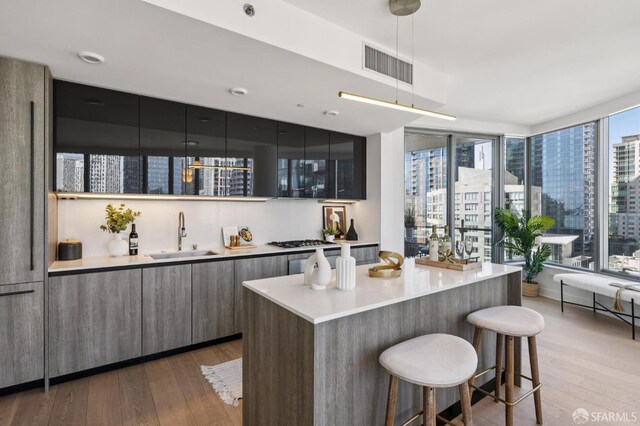 338 Main St Unit 19G, San Francisco, CA 94105 - bar area with wood-type flooring, hanging light fixtures, a view of city, and stainless steel gas stovetop
