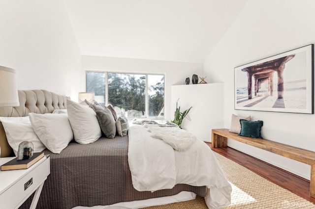 bedroom with hardwood / wood-style flooring and lofted ceiling