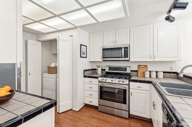 kitchen featuring white cabinetry, stainless steel appliances, tile countertops, and sink