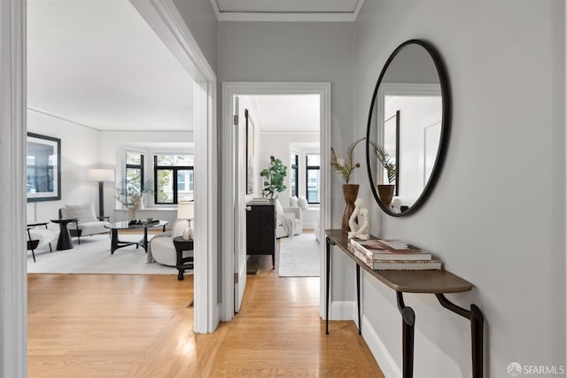 hallway featuring ornamental molding and light hardwood / wood-style floors