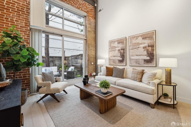 living room with a towering ceiling and light hardwood / wood-style floors