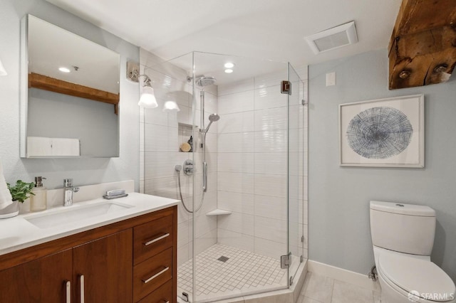 bathroom with vanity, a shower with shower door, tile patterned floors, and toilet