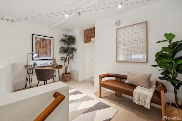 sitting room with beam ceiling, track lighting, and light hardwood / wood-style floors