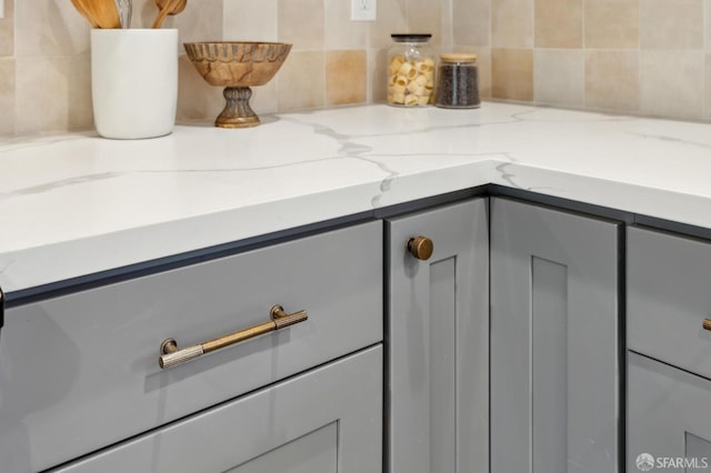 interior details featuring gray cabinetry and light stone countertops