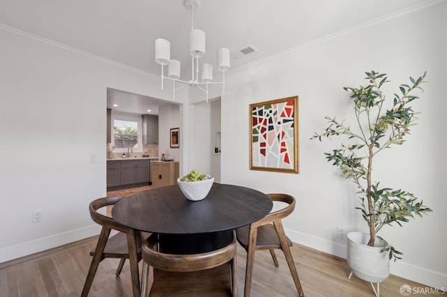 dining area with light wood-style floors, visible vents, and baseboards