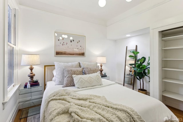 bedroom featuring baseboards and wood finished floors