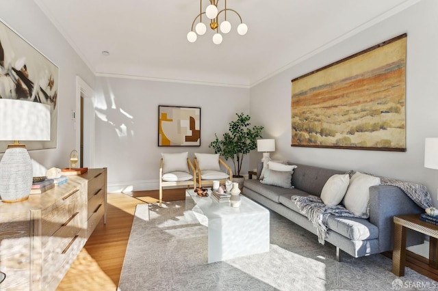 living room with light wood-type flooring, crown molding, baseboards, and an inviting chandelier