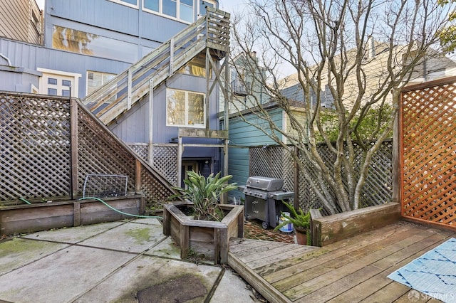 rear view of property featuring a patio, a wooden deck, and fence