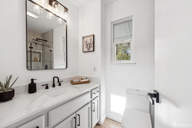 bathroom with vanity, a tile shower, and toilet