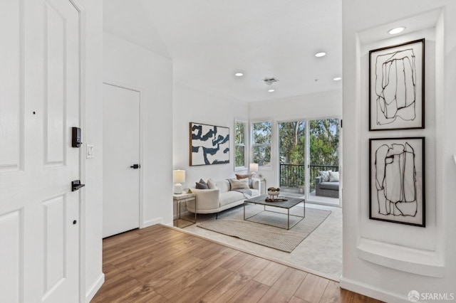 living room featuring recessed lighting, visible vents, ornamental molding, wood finished floors, and baseboards