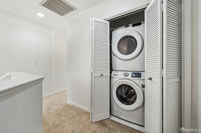 clothes washing area with recessed lighting, light colored carpet, visible vents, stacked washing maching and dryer, and laundry area