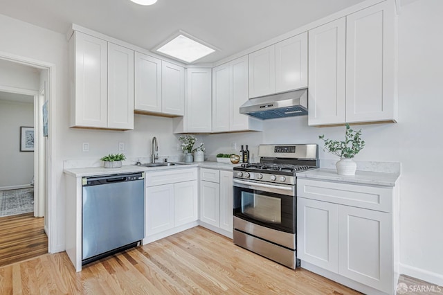 1567 44th Ave, San Francisco, CA 94122 - kitchen with appliances with stainless steel finishes, ventilation hood, light countertops, light wood finished floors, and white cabinets