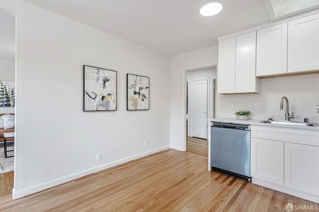 1567 44th Ave, San Francisco, CA 94122 - kitchen featuring stainless steel dishwasher, light countertops, light wood-style floors, and white cabinets