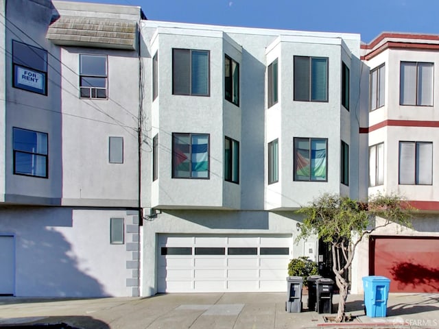 1279 41st Ave, San Francisco, CA 94122 - view of front facade with stucco siding, a garage, and driveway