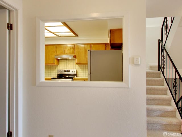 1279 41st Ave, San Francisco, CA 94122 - kitchen featuring stainless steel appliances, under cabinet range hood, and backsplash