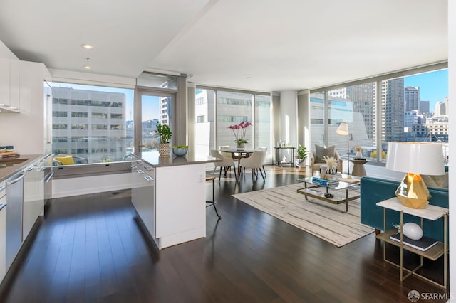 1 Hawthorne St Unit 12F, San Francisco, CA 94105 - kitchen featuring a city view, dark wood-style flooring, white cabinetry, a kitchen breakfast bar, and dark countertops